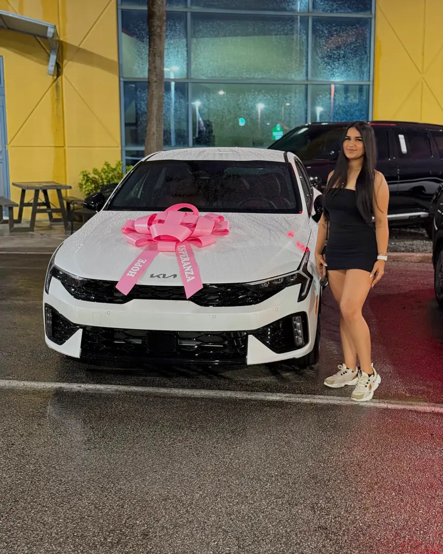 A Tier client beside her new vehicle outside the dealership.